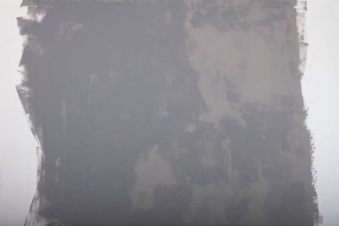 Evde gri boyalı bir duvar var, boya beyaz bir duvarda kuruyor..