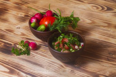 Taze sebze, domates, salatalık, dereotu, turp salatası ve ahşap bir masa için gerekli malzemeler..