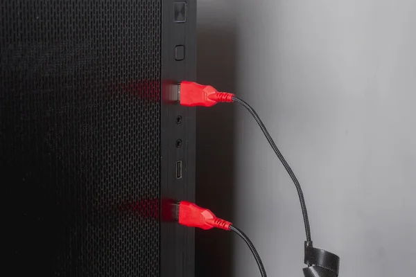 The red USB cord is inserted into the USB port of the computer — Stock Photo, Image