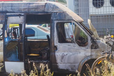 Yangından sonraki araba şehir caddesinde siyah kurum ile kaplı..