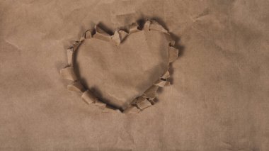 Kalp yırtık kahverengi kağıttan yapılmıştır. Arkaplan.
