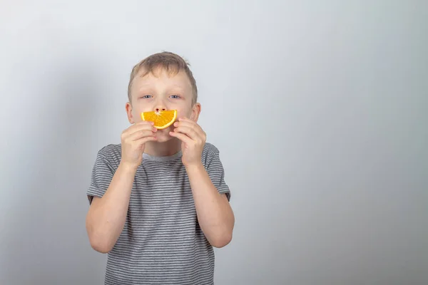 Joyeux Caucasien Garçon Sourit Fait Sourire Partir Une Tranche Orange — Photo