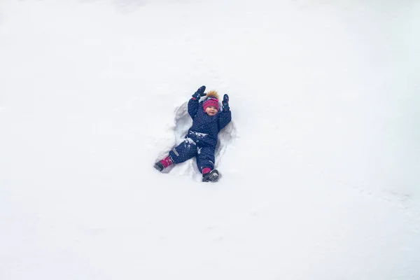 Baby Girl Lies Snow Winter Waves Her Hands Portraying Angel — Stock Photo, Image