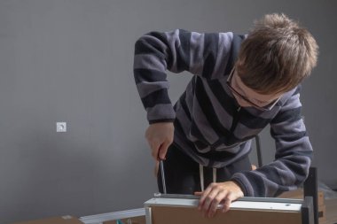 Kafkas çocuk 11 yaşında. Odasına tornavidayla mobilya kuruyor..