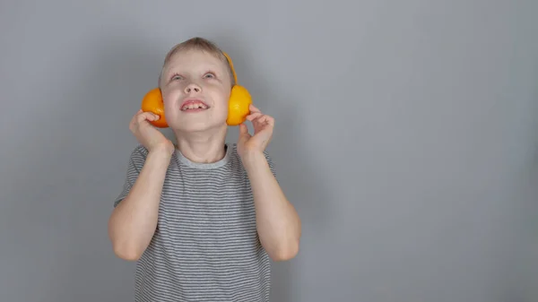 Ein Blonder Jähriger Kaukasischer Junge Grauem Shirt Und Orangefarbenen Kopfhörern — Stockfoto