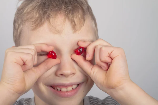 Веселий Хлопчик Дивиться Світ Через Червоні Капсули Медицини — стокове фото