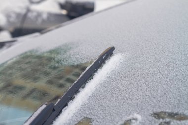 Arabadaki silecekler kışın ön camdan kar temizliyor..