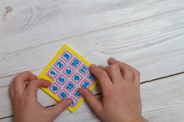 Çocuk sayı etiketi ile bir matematik oyunu oynuyor, sayıları doğru sıraya koyuyor.