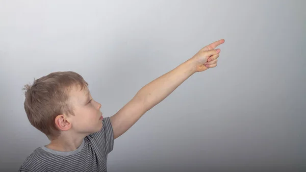 Кавказький Хлопчик Сірій Футболці Показує Пальці Збоку Дивиться Щось Подивом — стокове фото