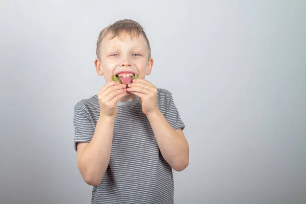 Ένα Καυκάσιο Αγόρι Τρώει Πράσινα Ακτινίδια Και Γελάει Και Χαμογελάει — Φωτογραφία Αρχείου