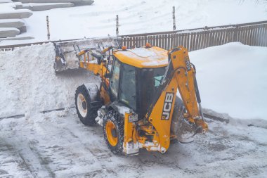 02 06 2022 Rusya Kostroma Turuncu Buldozer kar temizleme için kışın yolda kar temizliyor.