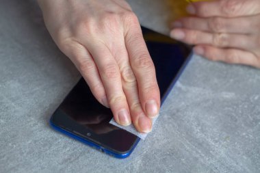 Yeni bir koruyucu cam takmadan önce akıllı telefon ekranını bir peçeteyle sil.