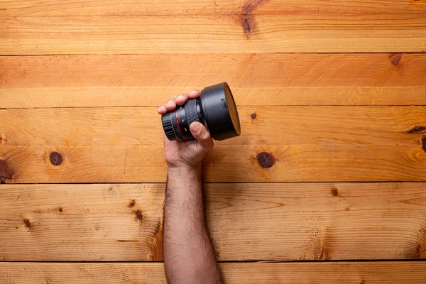 Hand Grabbing Camera Lens Light Wood Background Labor Day — Stock Photo, Image