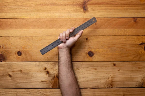 Hand Grabbing Metal Ruler Light Wooden Background Labor Day — Stock Photo, Image