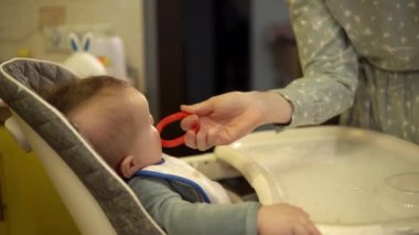 Anne, yemek yedikten sonra fırçalayarak küçük oğluna ilk dişlerini temizliyor.