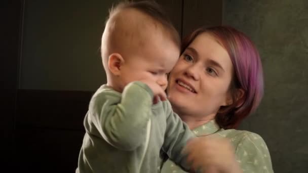 年轻的高加索女士双手托着熟睡的新生儿子，微笑着站在房间里 — 图库视频影像