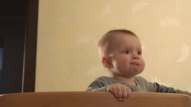 Happy baby stoi w łóżeczku z koją w ustach pozbywając się go i skacząc w zbliżeniu — Wideo stockowe