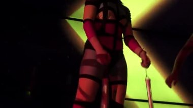 Arka planda neon ışıkları olan ve gece kulübünde dans eden Gogo Lady 'nin yakından görüntüsü.