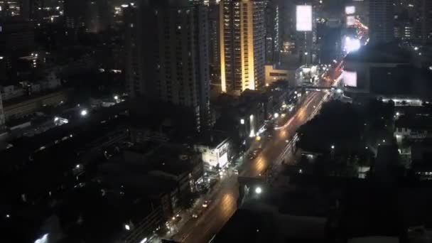 Luchtfoto van de nacht stad met bewegende auto 's en heldere billboards op gebouwen in timelapse — Stockvideo