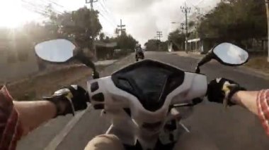 Tayland yolunda motosiklet süren bir adamın zamanı yaz günü filme alınır.