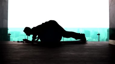 Adam bir fitbol topuna uzanıyor ve bacaklarını hiperuzatma siluetine kaldırıyor.