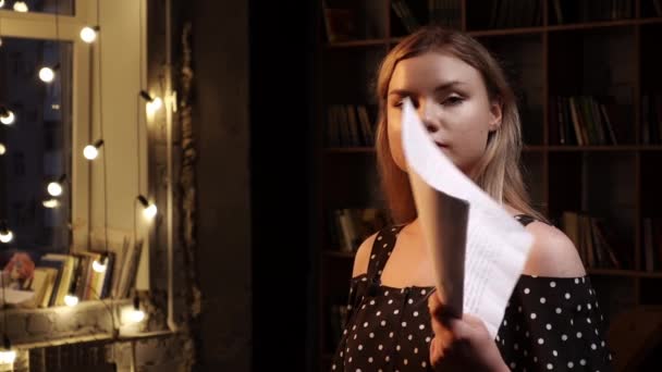 Fiatal komoly nő áll a szobában, és integet papírlapokkal a kezében mond valamit. — Stock videók