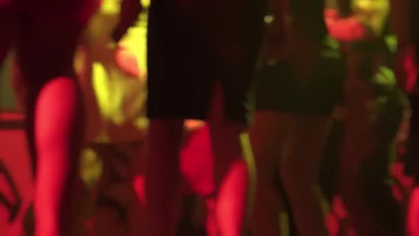 Señoras jóvenes en vestidos cortos sexy están pasando tiempo en el club nocturno bailando en la multitud — Vídeos de Stock