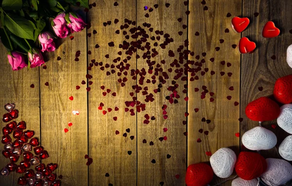 Festive design made of heart shaped decorations and tender pink roses lying on wooden table — Fotografia de Stock