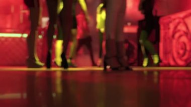 View of women legs wearing high heels shoes and dancing in nightclub