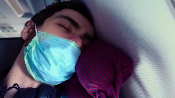 Un hombre duerme con la cabeza apoyada en la pared de un avión con máscara facial en primer plano — Vídeos de Stock