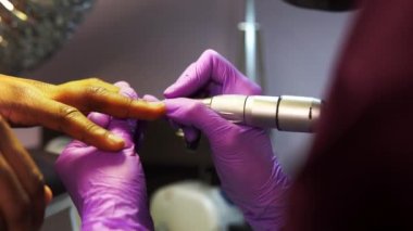 Makro profil görüntüsü kadın elleri siyah adam için aparat manikür yapıyor