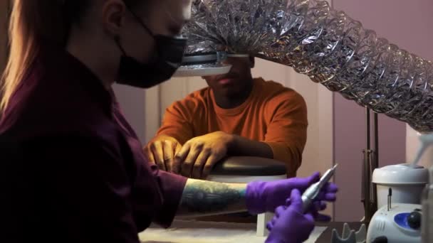 Femmina maestro di bellezza sta cambiando l'ugello prima di fare manicure apparecchio per un uomo nero — Video Stock
