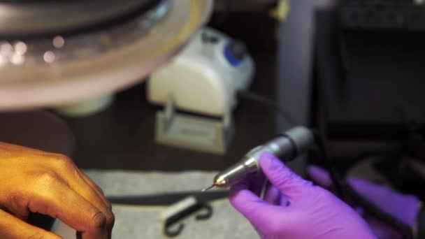 美容師はマシンを設定する黒人男性に機器マニキュアを作るための準備をしています — ストック動画