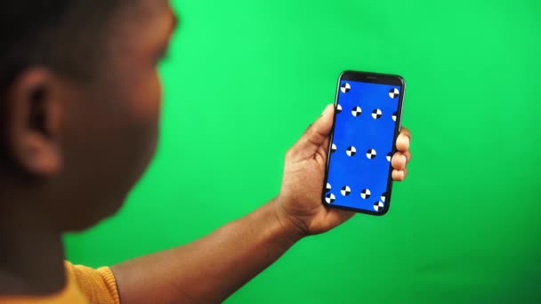 黑人们把智能手机上的内容放大，在绿色屏幕上显示跟踪标记 — 图库视频影像