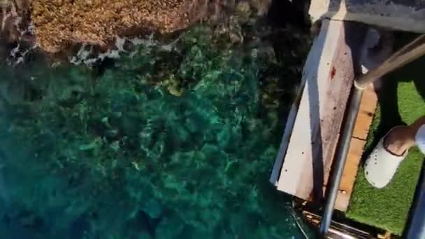 Niedriger Abschnitt der Männerbeine, der am Rand der Treppe steht, die unter Wasser führt, von oben gefilmt — Stockvideo