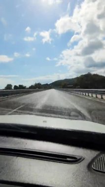 Güneşli yaz gününde ağaçların ve dağların arasında yılanlı yolda giden arabanın zamanı.