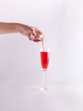 Uzun flüt bardakları, adamın eli Noel mücevherinden kırmızı bir içecek dolduruyor. Yaratıcı Yeni Yıl parti düzeni. 