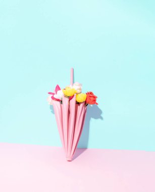 Pembe şemsiye ve renkli çiçekler. Yaratıcı çiçek çizimi. Bahar yağmuru fikri. 