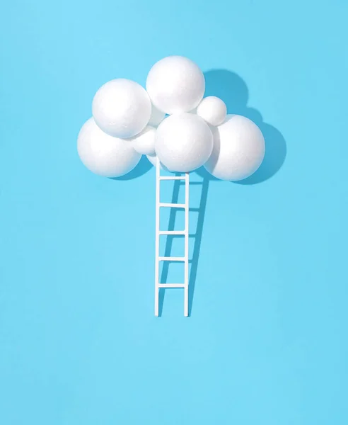 A cloud of foam balls and ladders, a minimal creative concept. Climbing the ladder of success idea.