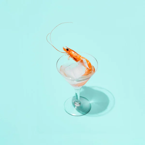 Cocktailglas Eiswürfel Und Eine Garnele Kreatives Arrangement Vor Pastellblauem Hintergrund — Stockfoto
