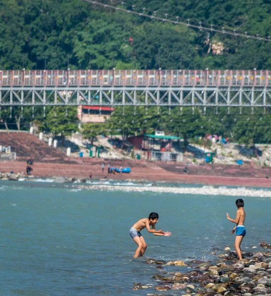 Children playing in river with water, rishikesh view with ganga river.