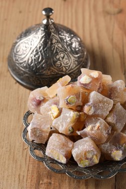 Turkish delight with pistachio in a copper plate on a wooden floor