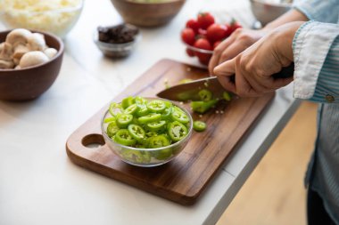 Biber kesimi, tahtada biber doğrayan kadın.