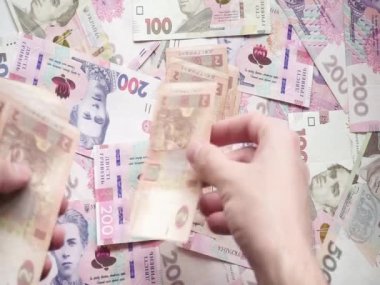 Ukrayna kağıt banknotlarının bir insanın elinde iki hryvnia değerinde hesabı