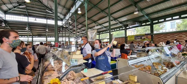 Клиенты, выбирающие сыр на рынке в Ренне, Франция — стоковое фото