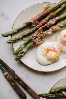 haşlanmış yumurtalı kuşkonmaz. Prosciutto ya da jambonla süslenmiş haşlanmış yeşil kuşkonmaz. Kuşkonmazlı sağlıklı ve lezzetli bir kahvaltı. Kuşkonmaz üst görünümü olan atıştırmalıklar.