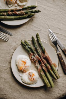 haşlanmış yumurtalı kuşkonmaz. Prosciutto ya da jambonla süslenmiş haşlanmış yeşil kuşkonmaz. Kuşkonmazlı sağlıklı ve lezzetli bir kahvaltı. Kuşkonmaz üst görünümü olan atıştırmalıklar.