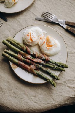 haşlanmış yumurtalı kuşkonmaz. Prosciutto ya da jambonla süslenmiş haşlanmış yeşil kuşkonmaz. Kuşkonmazlı sağlıklı ve lezzetli bir kahvaltı. Kuşkonmaz üst görünümü olan atıştırmalıklar.
