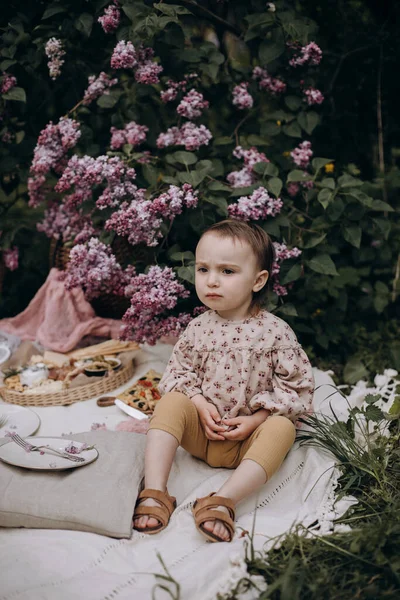 Little Girl Serious Look Sits Picnic Blanket Park Garden Girl — Stok Foto