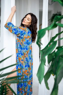 Açık renk uzun elbiseli güzel sarışın kadın tropikal tatil köyünde.